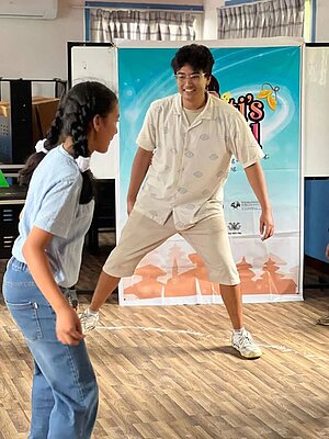 A workshop facilitator trying out a game designed by school participants.