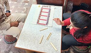 Learning the Kasimala Pya game with the help of a school teacher also a heritage enthusiast, Sabin Duwal.