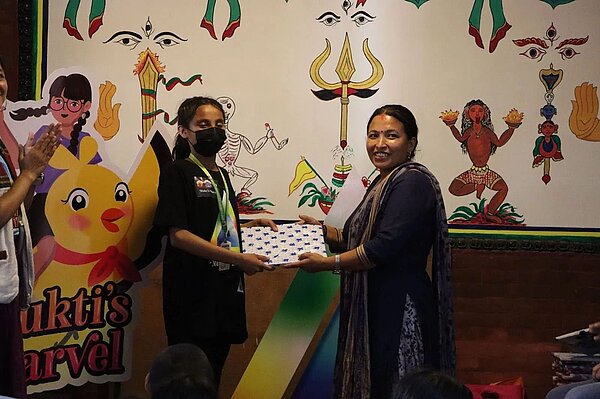 A workshop facilitator trying out a game designed by school participants.