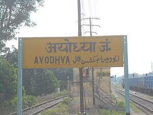 Sign board of Ayodhya next to railroads.