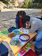 Let’s Play volunteer and a child from Bhaktapur are playing the Baghchal game.