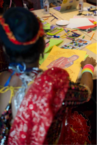 A Tharu natuwa finishing their self-portrait.